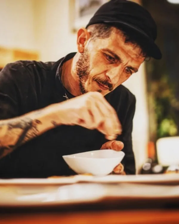 Marco Genna finishing a dish, seasoning it by hand